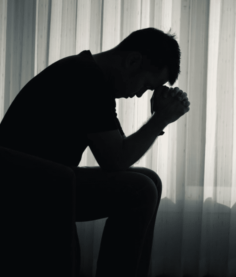 man praying alone in his room