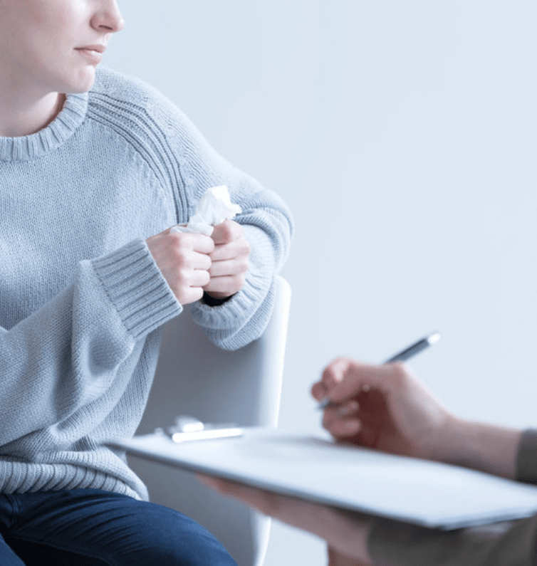 woman holding a tissue in therapy session