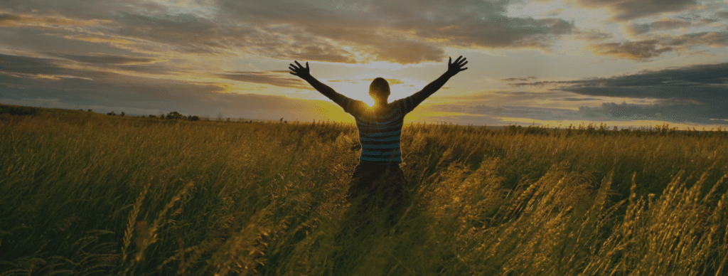 man feeling freedom outside in field