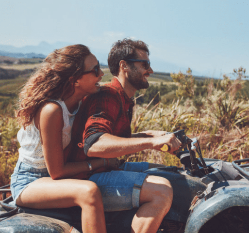 smiling man and woman on motorcycle