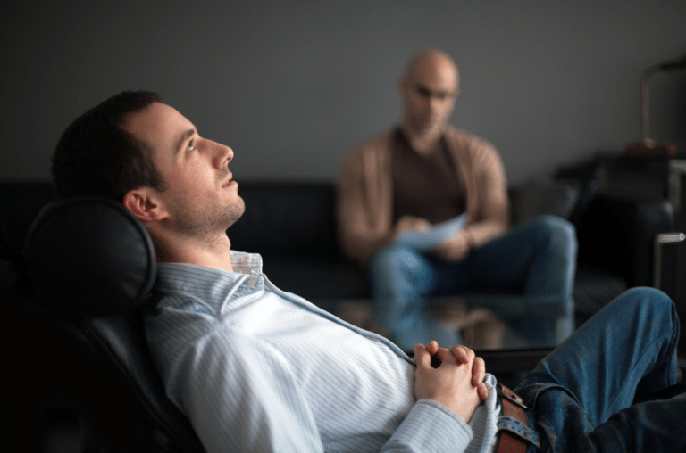man laying down looking at sky while therapist listens