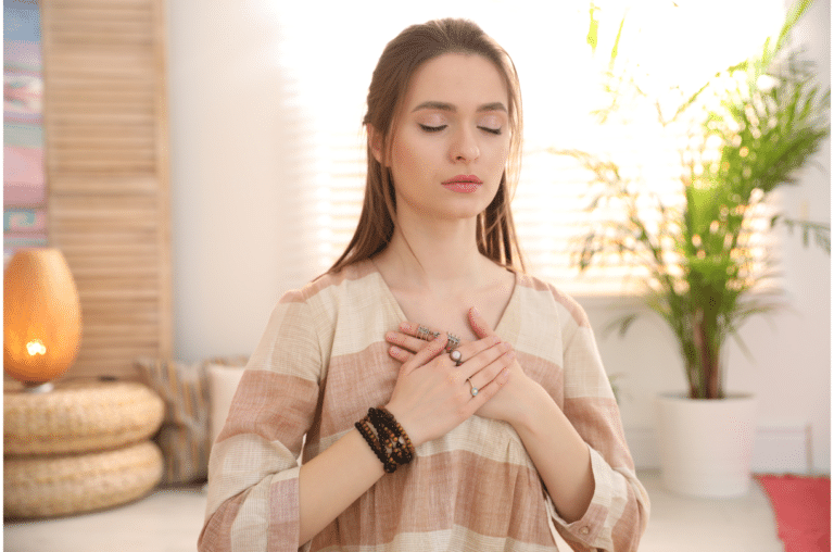 woman holding her hands over her heart with eyes closed