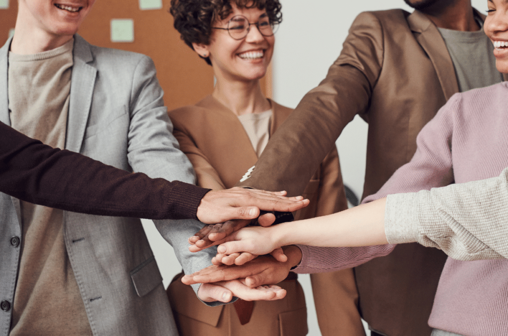 group of coworkers putting their hands together