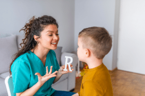 woman therapist teaching a little boy the alphabet