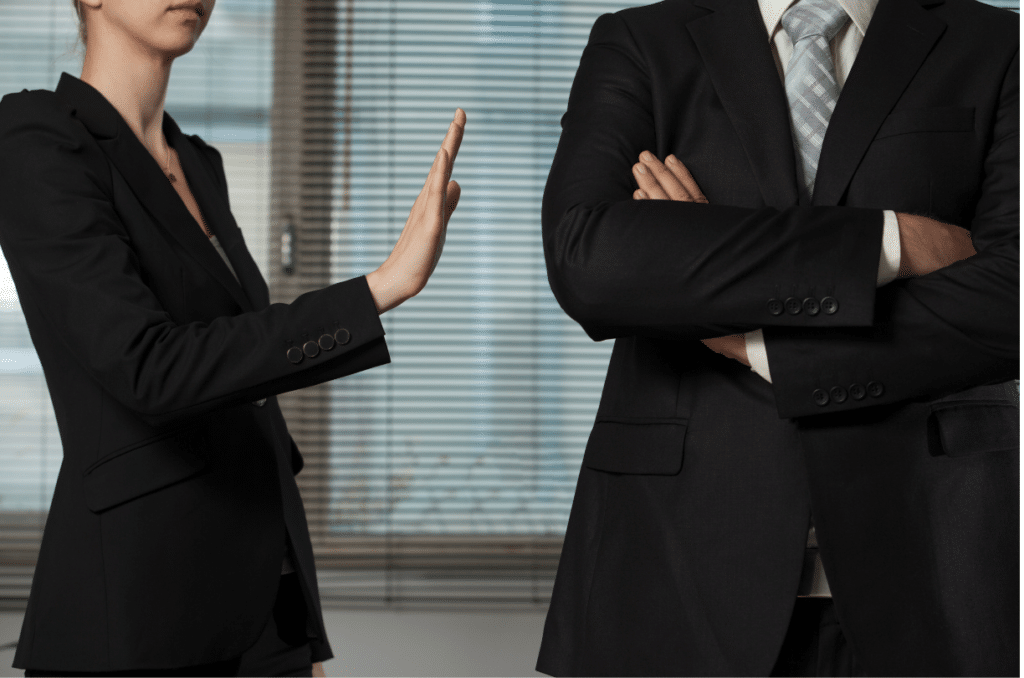 corporate woman putting hand up to corporate man