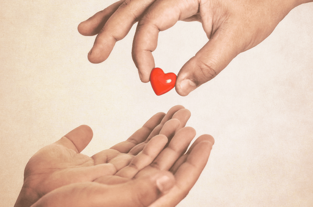hand giving a heart icon to another hand
