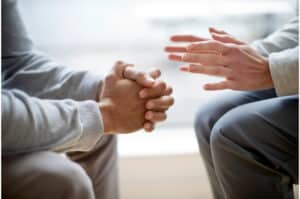 two men talking to each other and listening