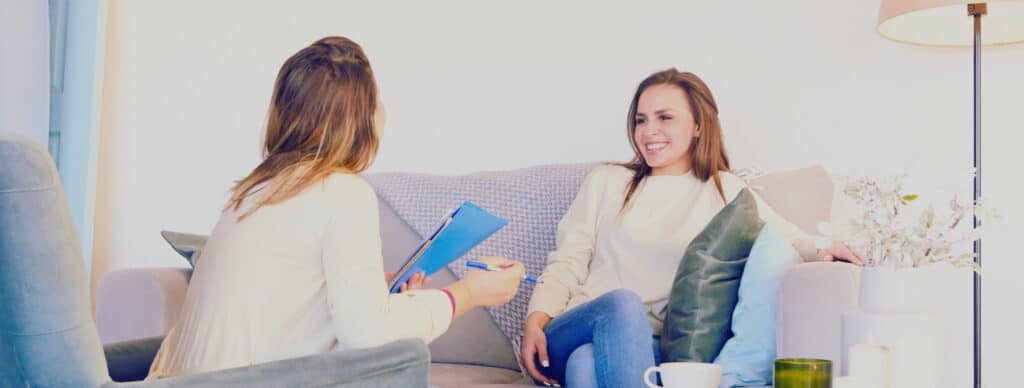 woman sitting on couch talking with therapist