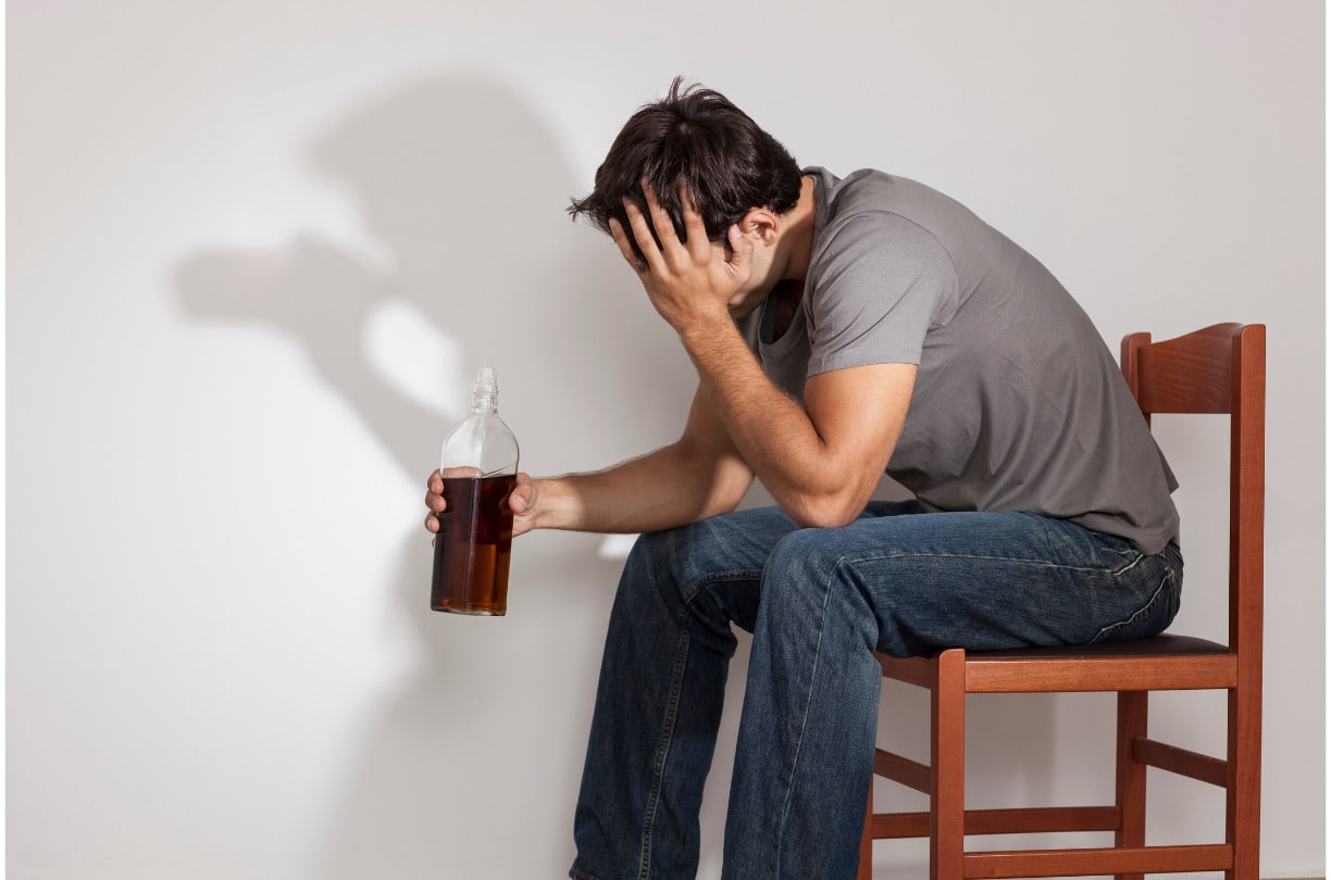 man drinking alcohol while stressed out