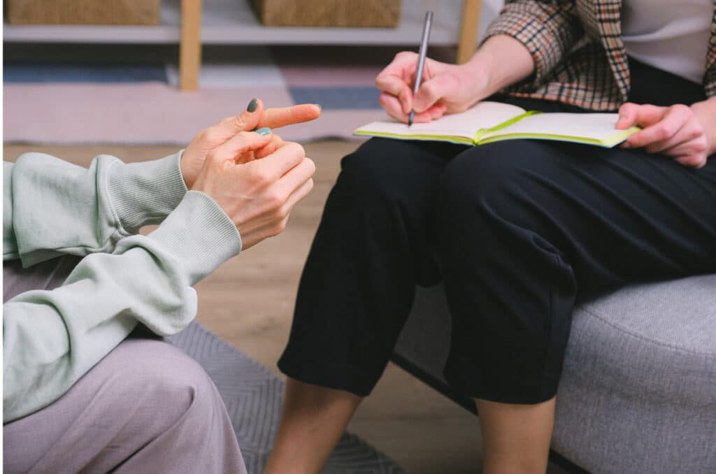 therapist taking notes as client talks