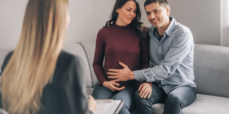 happy pregnant couple talking to therapist