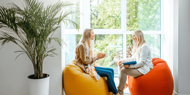 two woman talking on chairs