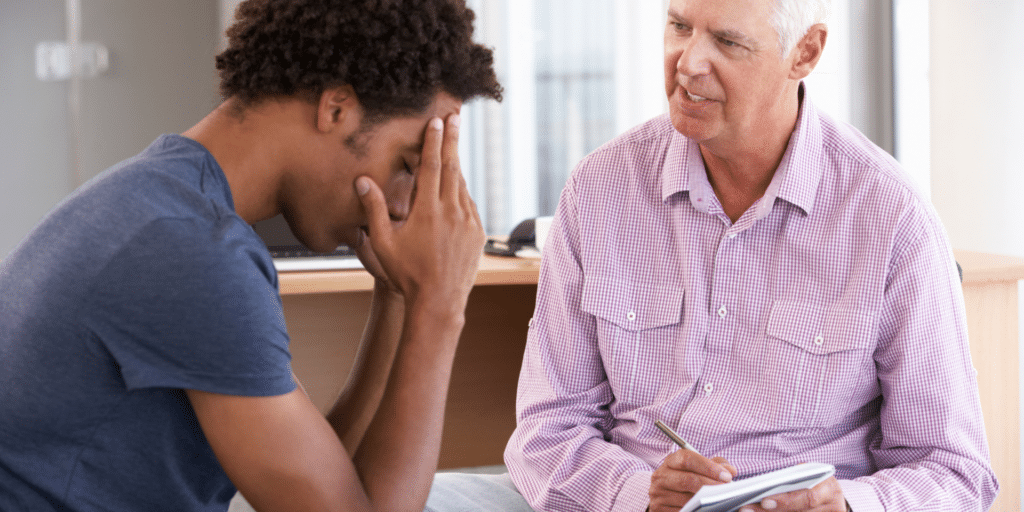 distressed man listens to therapist