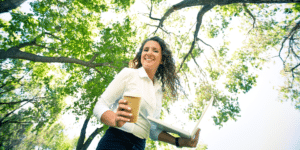 happy woman smiling outside with her coffee