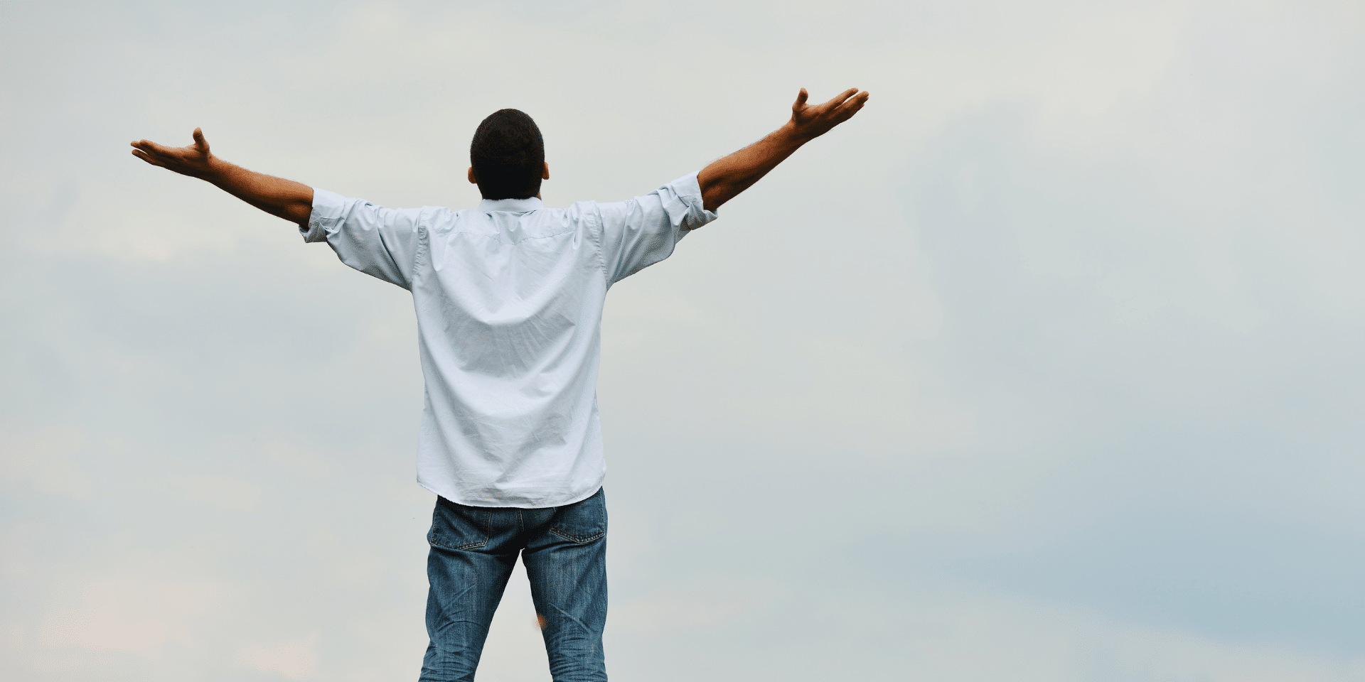 man feeling free with arms spread out, outside