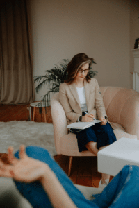 therapist takes notes and listens while client talks