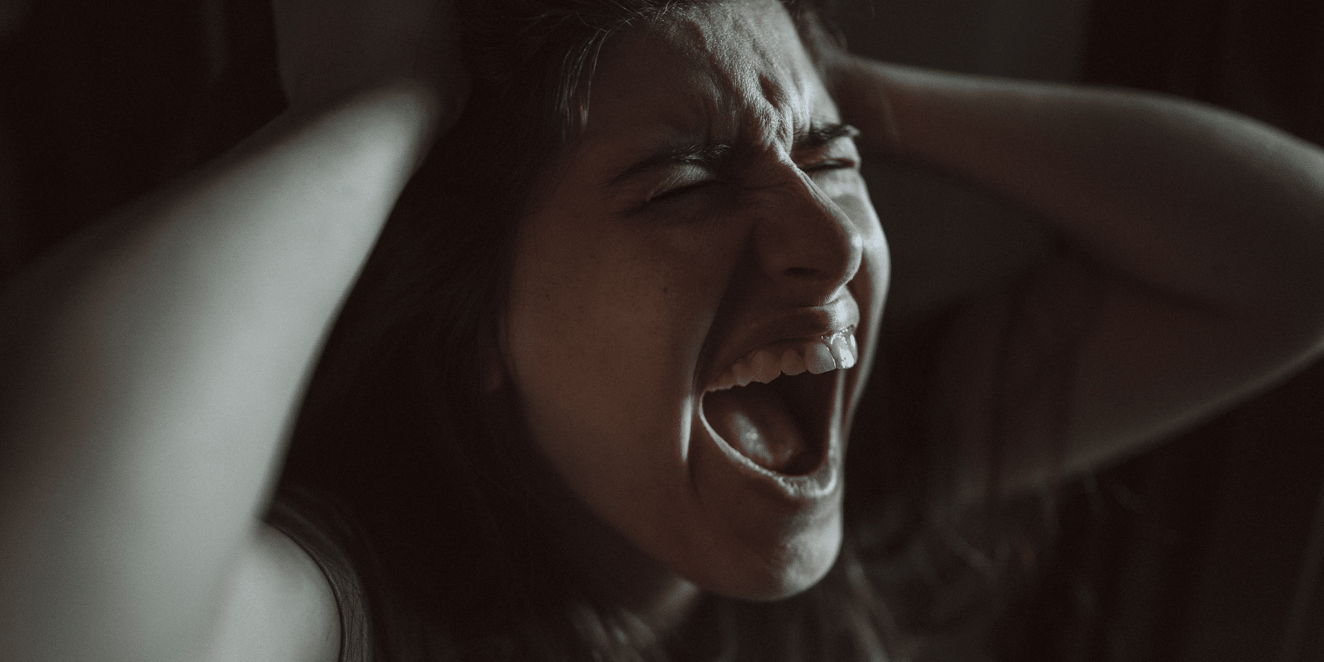 woman screaming while holding head