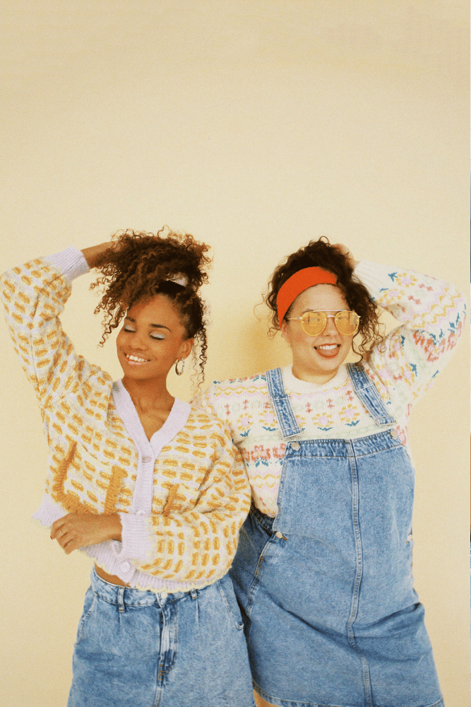 two woman standing side by side while looking happy