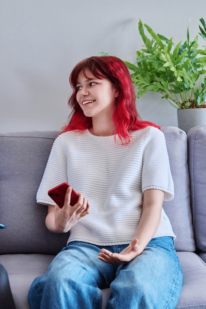 teenager with red hair sitting on a couch taking to her therapist