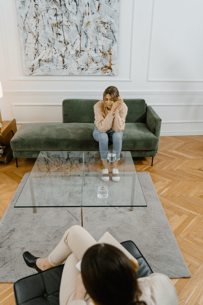 woman client sitting on a couch talking to her female therapist