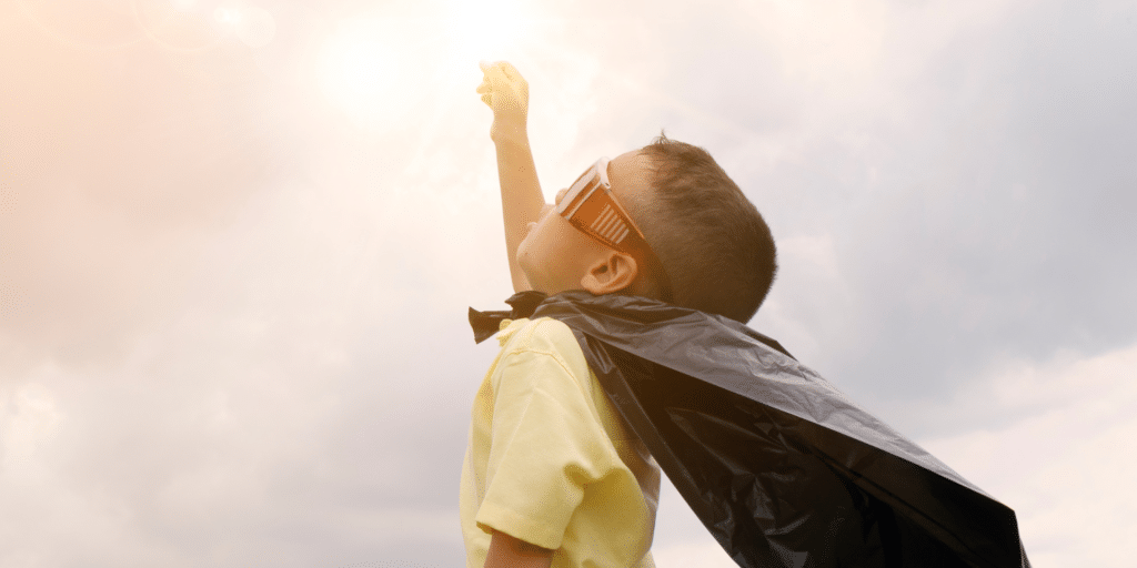 superhero kid looking up to the sky feeling optimistic