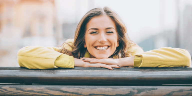 girl smiling while leaning on a railing