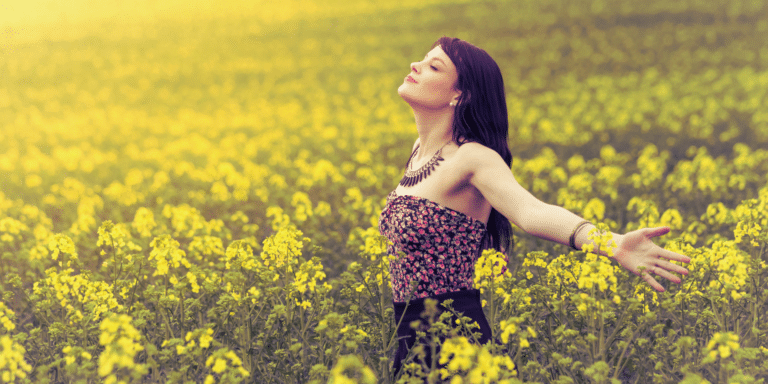 woman enjoying the flowers outside in a field