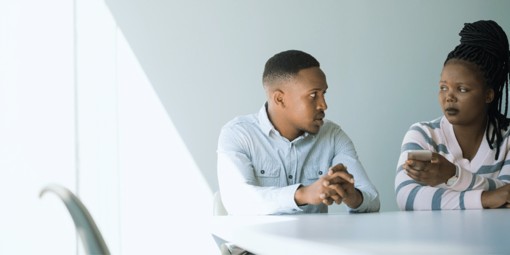 a man in a woman looking at each other, couples counseling, they look upset with one another