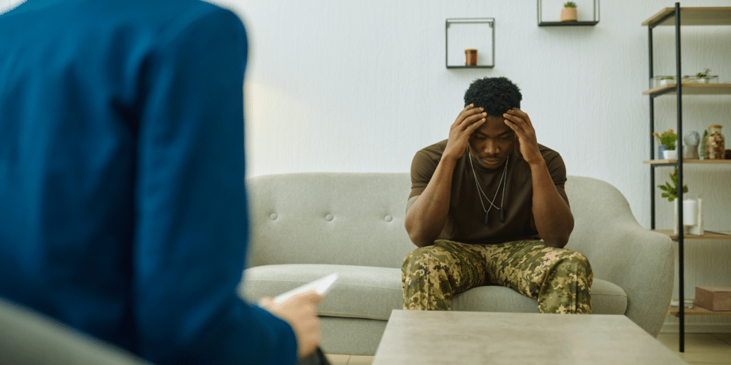 client grabbing his head thinking about trauma or PTSD in therapy