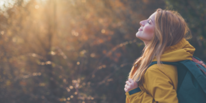 happy woman looking up toward the sun and feeling free, post therapy session