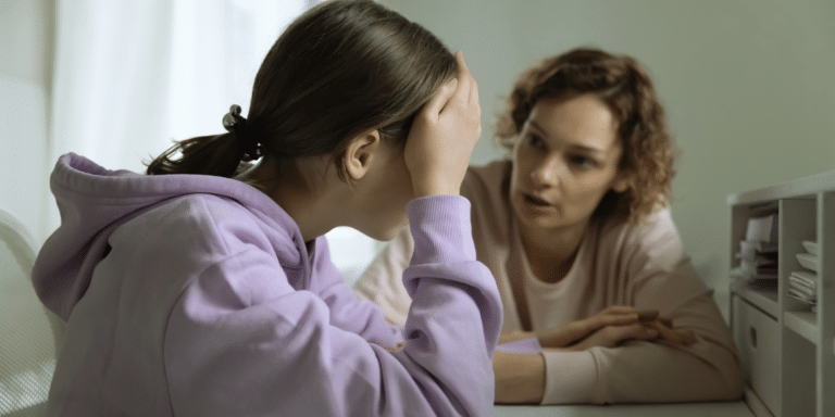 woman adult therapist talking to her female teenage client. client looks distressed