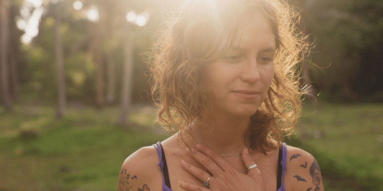 a woman holding her hand up to her chest to represent a deep connection and/or feeling she is experiencing