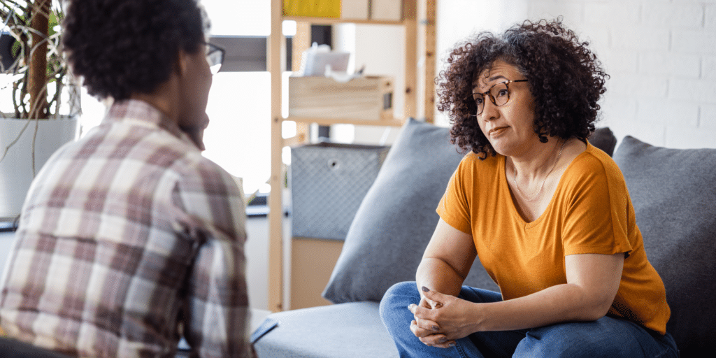 Two people in therapy counseling session on a couch in Denver, Colorado