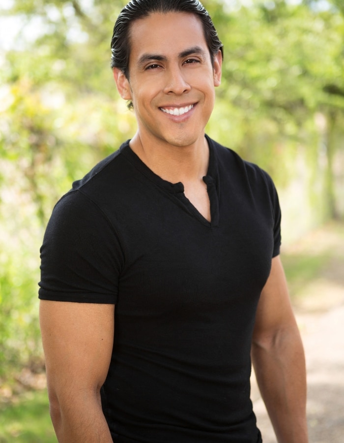 Smiling Hispanic man outdoors in the sun, representing hope and healing through therapy