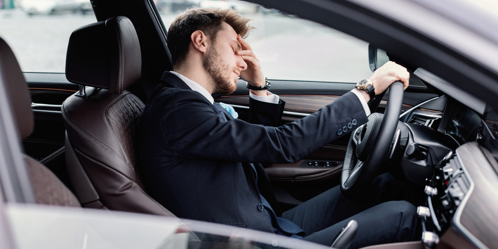 Exhausted businessman resting his head in his hand in his car, a sign of high-functioning depression