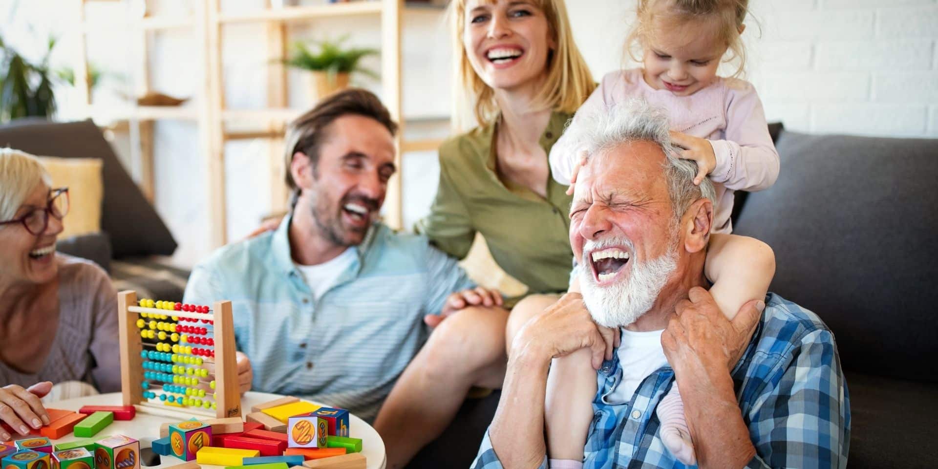 Laughing grandparents playing with their grandchildren at home