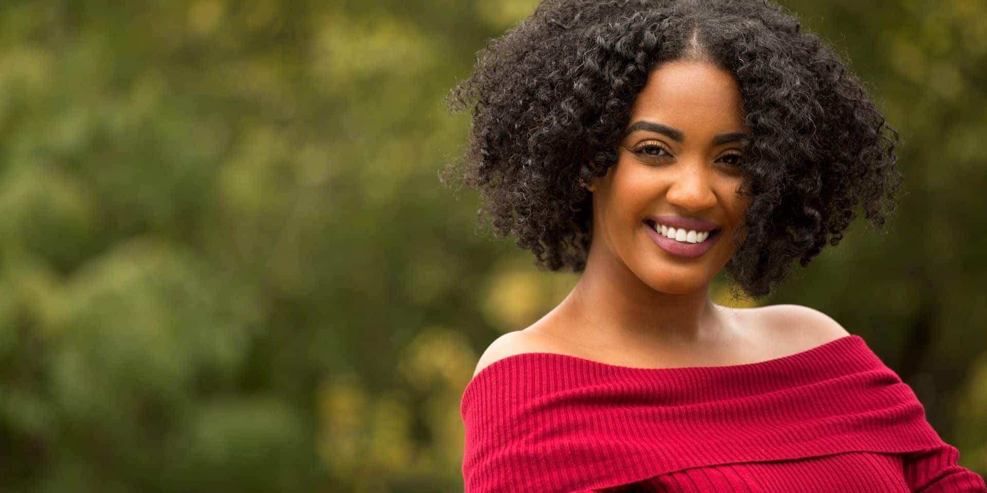 Smiling Black woman with curly hair outdoors